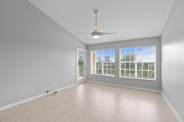 empty room featuring a ceiling fan, light tile patterned flooring, vaulted ceiling, and baseboards