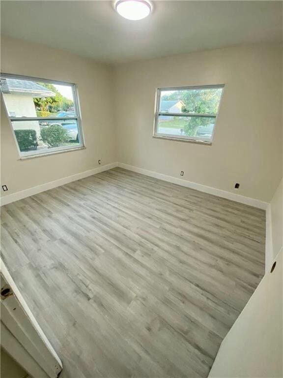 unfurnished room with a wealth of natural light and light hardwood / wood-style flooring