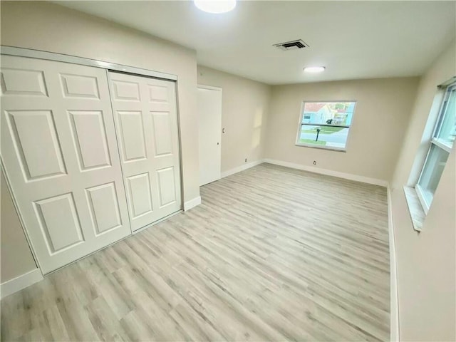 unfurnished bedroom featuring light hardwood / wood-style floors and a closet