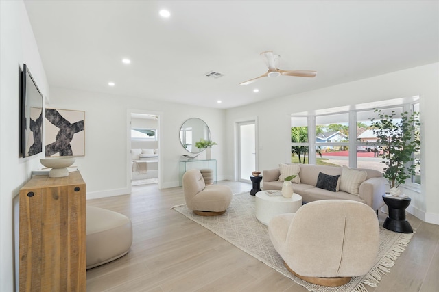 living room featuring light wood-type flooring and ceiling fan