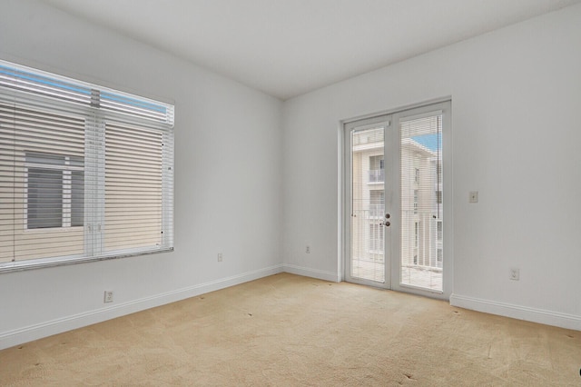 spare room with light carpet and french doors