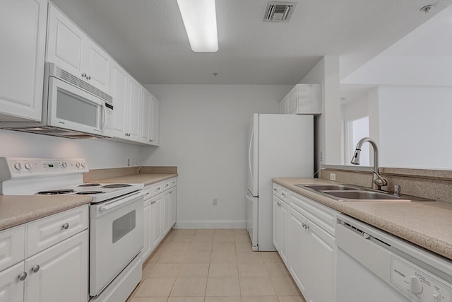 kitchen with sink, white appliances, white cabinetry, and light tile patterned flooring