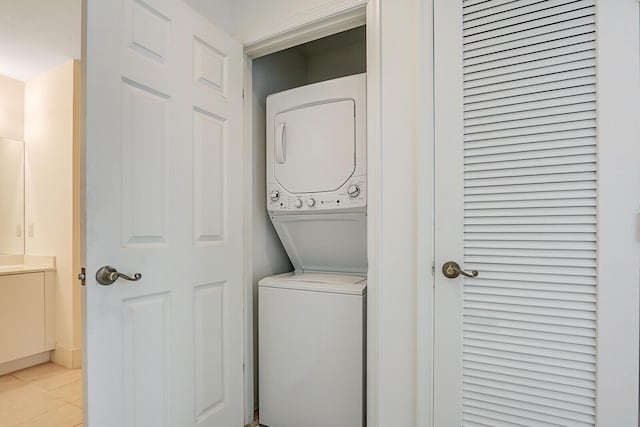 washroom featuring light tile patterned floors and stacked washer and clothes dryer