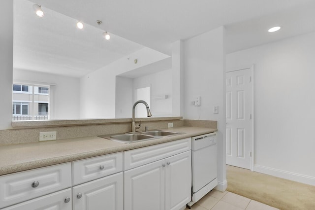 kitchen with sink, white cabinetry, light tile patterned floors, and dishwasher