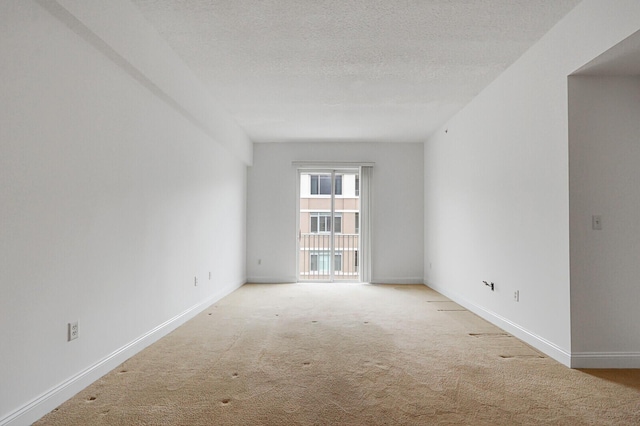 unfurnished room with a textured ceiling and light colored carpet