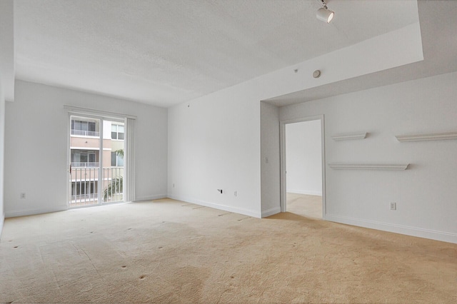 carpeted spare room featuring a textured ceiling