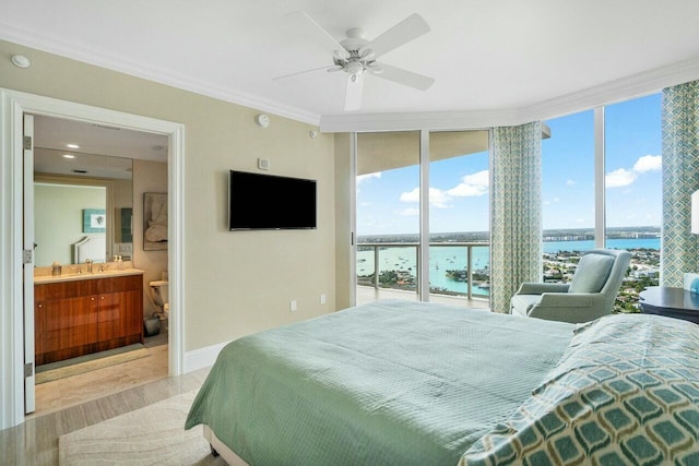 bedroom with connected bathroom, a wall of windows, ornamental molding, light wood-type flooring, and ceiling fan