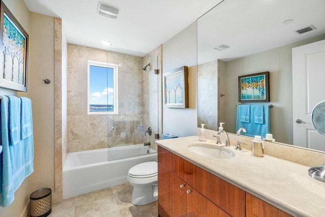 full bathroom with toilet, vanity, and tiled shower / bath