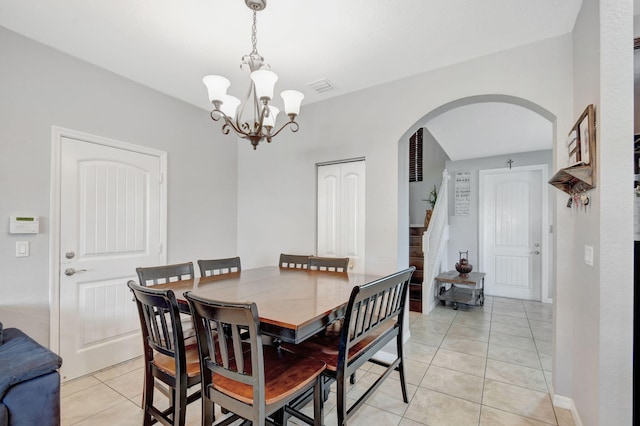 dining area with light tile patterned floors and a notable chandelier