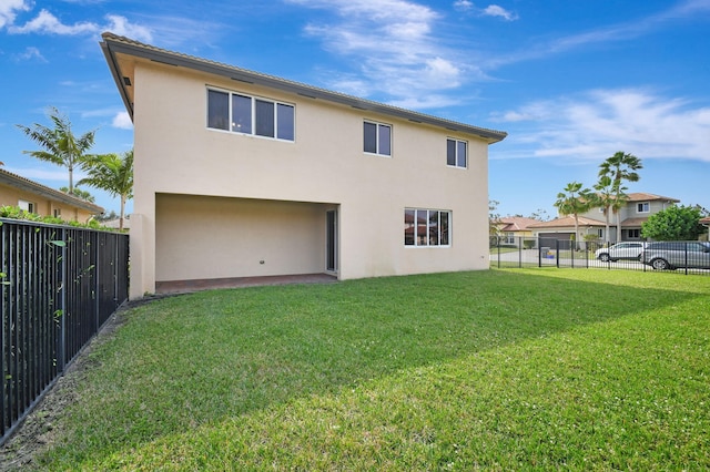 rear view of house featuring a lawn