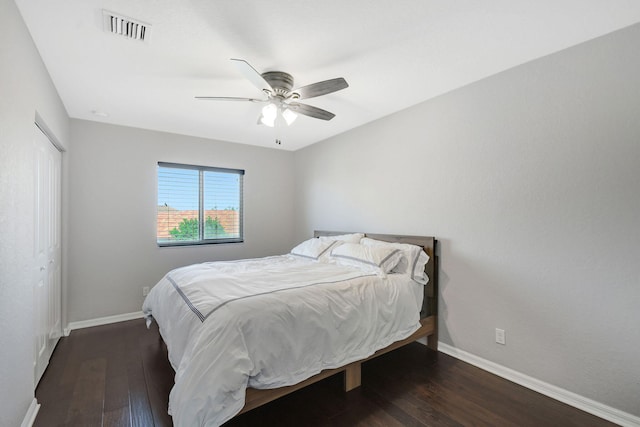 bedroom featuring ceiling fan, a closet, and dark wood-type flooring