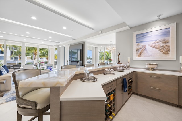 kitchen featuring a breakfast bar, kitchen peninsula, a wealth of natural light, and floor to ceiling windows