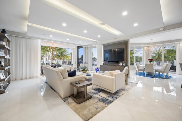 living room featuring a wealth of natural light, a wall of windows, and a notable chandelier