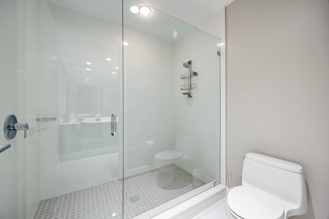 bathroom with toilet, tile patterned floors, and a shower with shower door