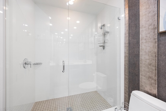 bathroom featuring tile patterned floors, an enclosed shower, and toilet