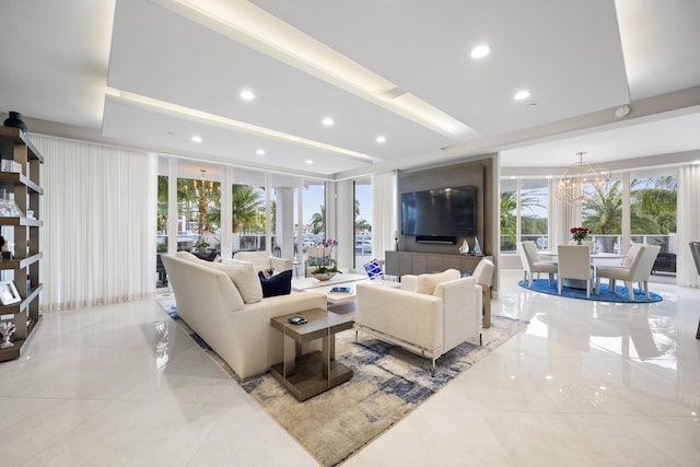 living room with an inviting chandelier, a healthy amount of sunlight, and a wall of windows