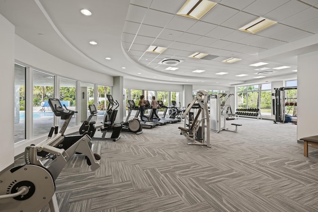 exercise room featuring light carpet and a paneled ceiling