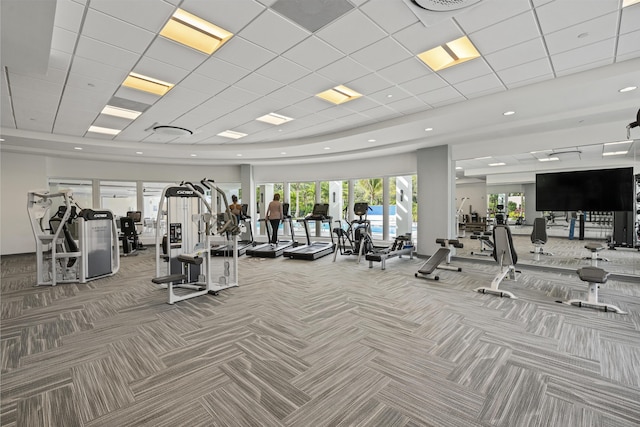 gym with a paneled ceiling and carpet floors