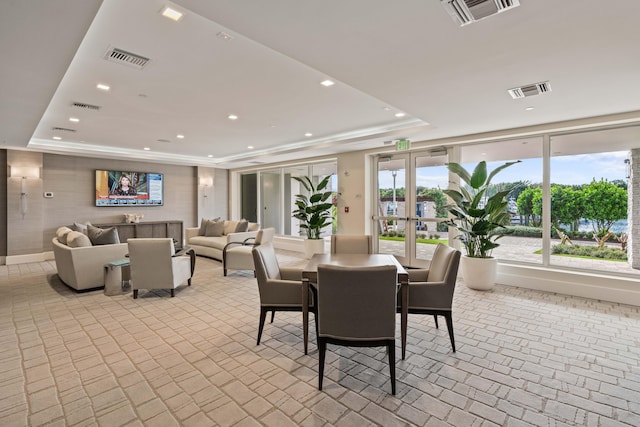 dining room featuring a healthy amount of sunlight, french doors, and a tray ceiling