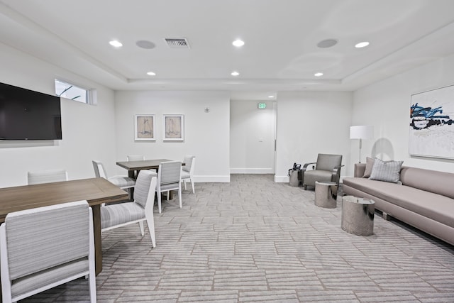 living room with light colored carpet and a tray ceiling