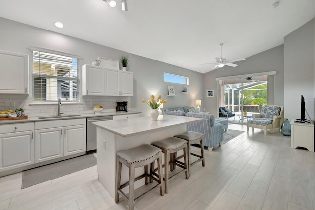 kitchen featuring white cabinetry, sink, stainless steel dishwasher, and a center island