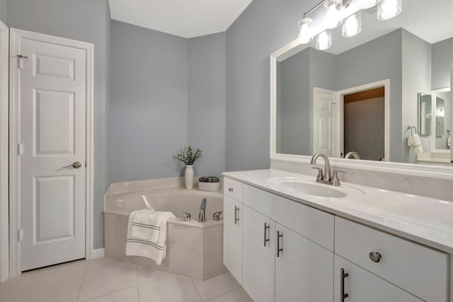 bathroom with tile patterned floors, a bath, and vanity