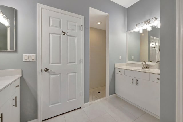 bathroom featuring tile patterned floors, vanity, and a tile shower