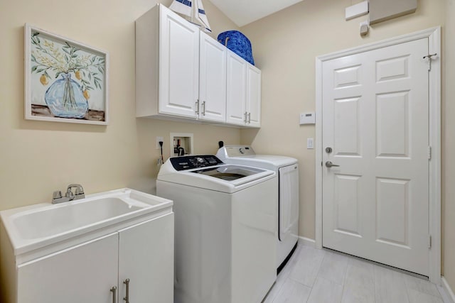 laundry area featuring cabinets, sink, and washing machine and dryer