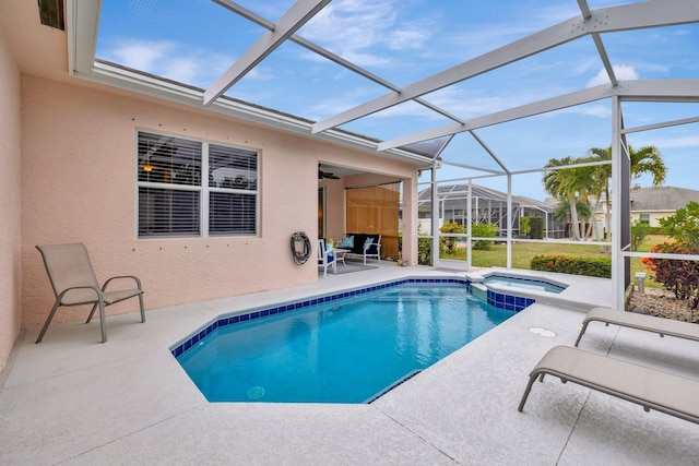 view of pool featuring an in ground hot tub, a patio area, and glass enclosure