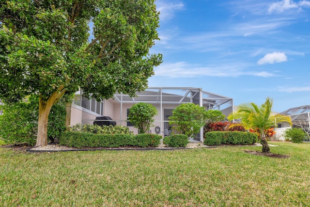 exterior space with a front yard and glass enclosure