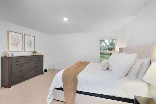 bedroom with a textured ceiling and light carpet