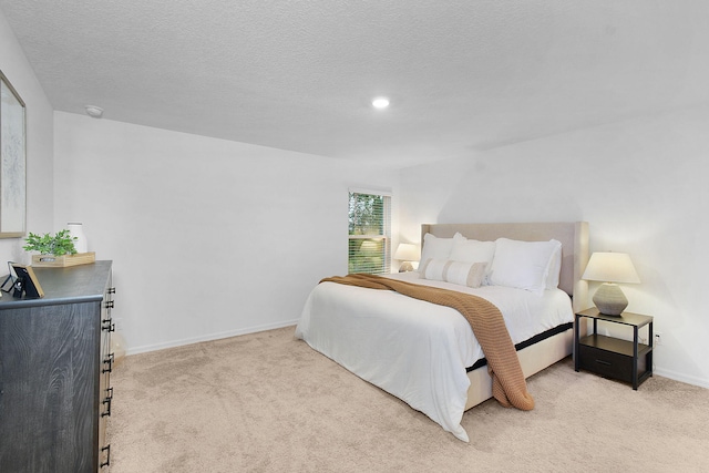 bedroom featuring light colored carpet and a textured ceiling