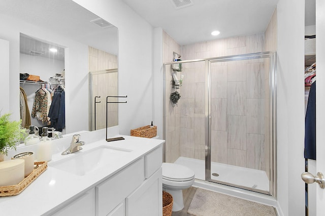 bathroom featuring vanity, toilet, and a shower with door