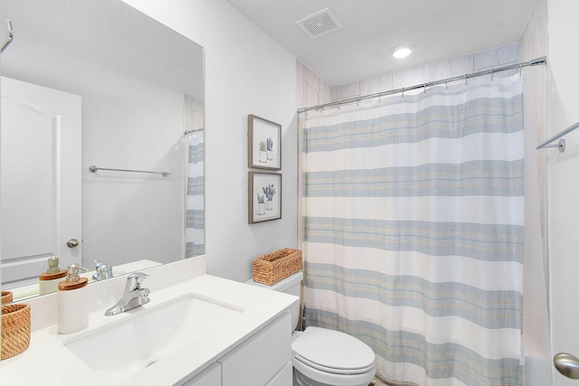 bathroom featuring toilet, vanity, and curtained shower