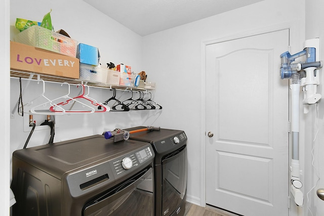 laundry room with washer and clothes dryer and wood-type flooring