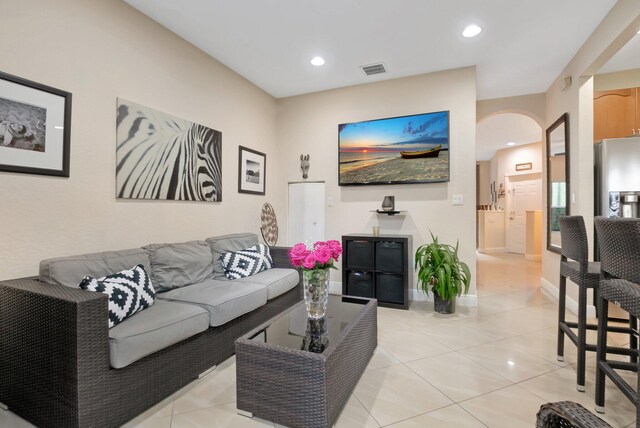 tiled living room with ceiling fan