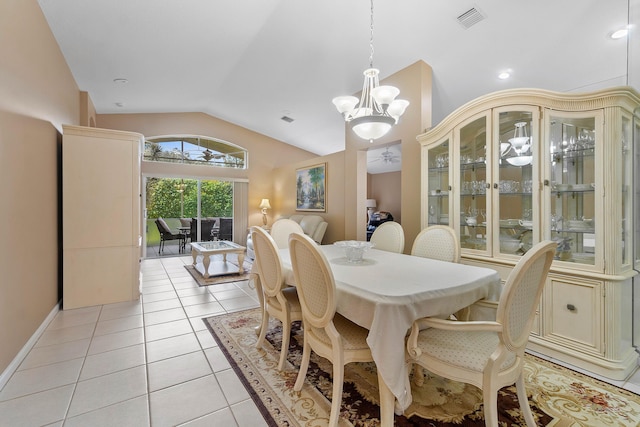 dining room featuring vaulted ceiling, light tile patterned floors, and a notable chandelier