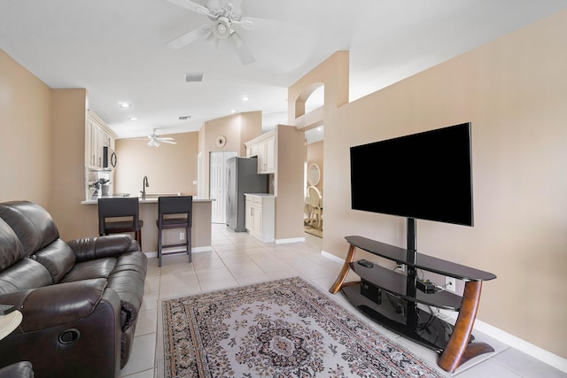 tiled living room featuring ceiling fan and sink