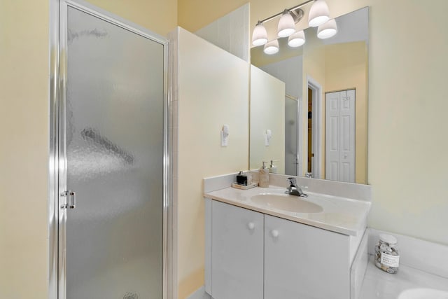 bathroom with a shower with shower door and vanity