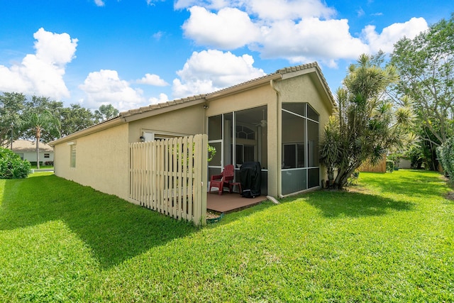 rear view of house with a sunroom and a yard