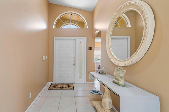 foyer featuring a wealth of natural light, light tile patterned floors, and a high ceiling