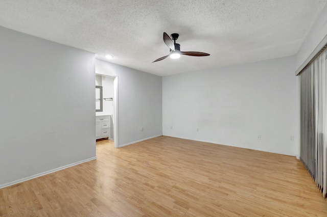 unfurnished bedroom featuring ceiling fan, ensuite bathroom, a textured ceiling, and light hardwood / wood-style flooring