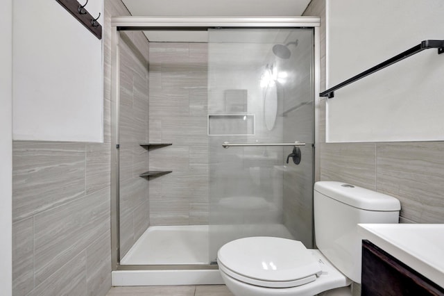 bathroom featuring toilet, tile walls, an enclosed shower, and vanity