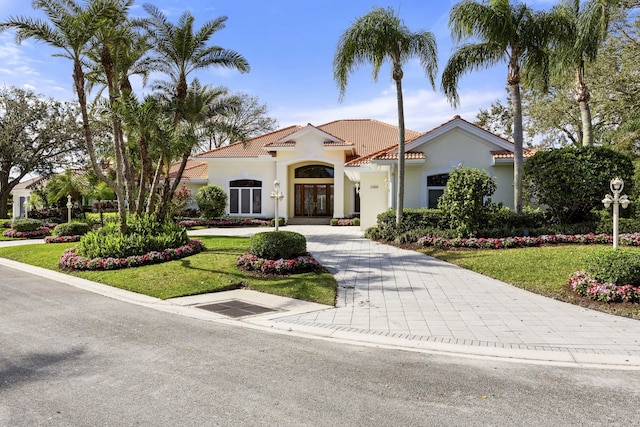 mediterranean / spanish home with a front yard