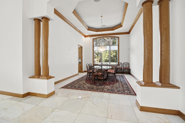 dining space with ornate columns, crown molding, and a tray ceiling