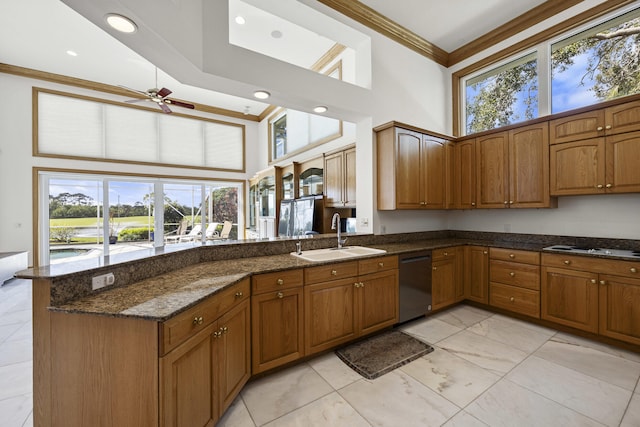 kitchen with sink, dark stone countertops, dishwasher, kitchen peninsula, and a towering ceiling