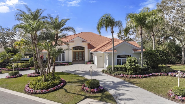 mediterranean / spanish-style home featuring a front yard and french doors