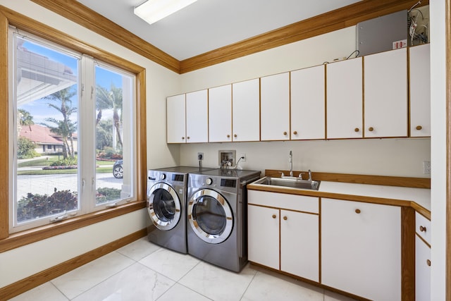 laundry room with cabinets, washing machine and dryer, sink, and crown molding