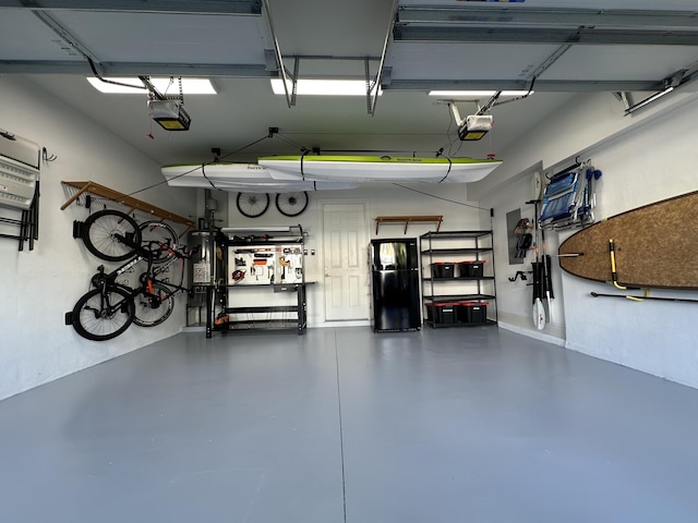 garage with a garage door opener and black refrigerator