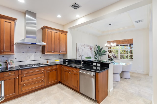 kitchen featuring an inviting chandelier, stainless steel appliances, decorative light fixtures, dark stone counters, and wall chimney range hood